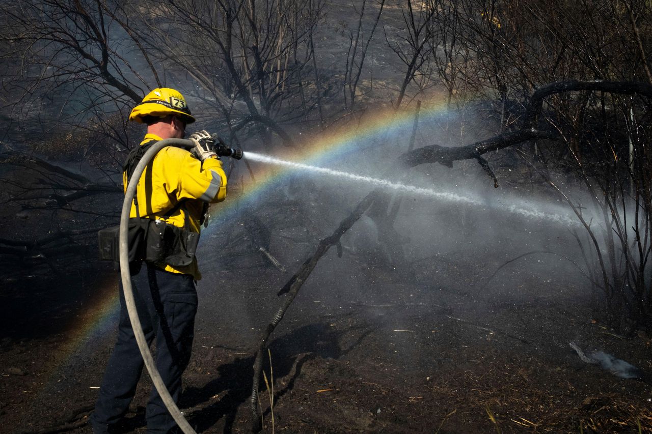 source:Independent - Invito di Newsom a Trump - Un pompiere spegne i focolai dell'incendio Archer a Los Angeles.