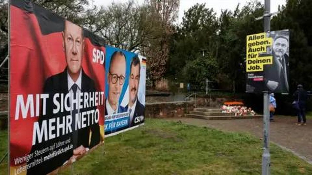 Reazioni politiche all'attacco - Manifesti elettorali per il cancelliere tedesco e il principale candidato.