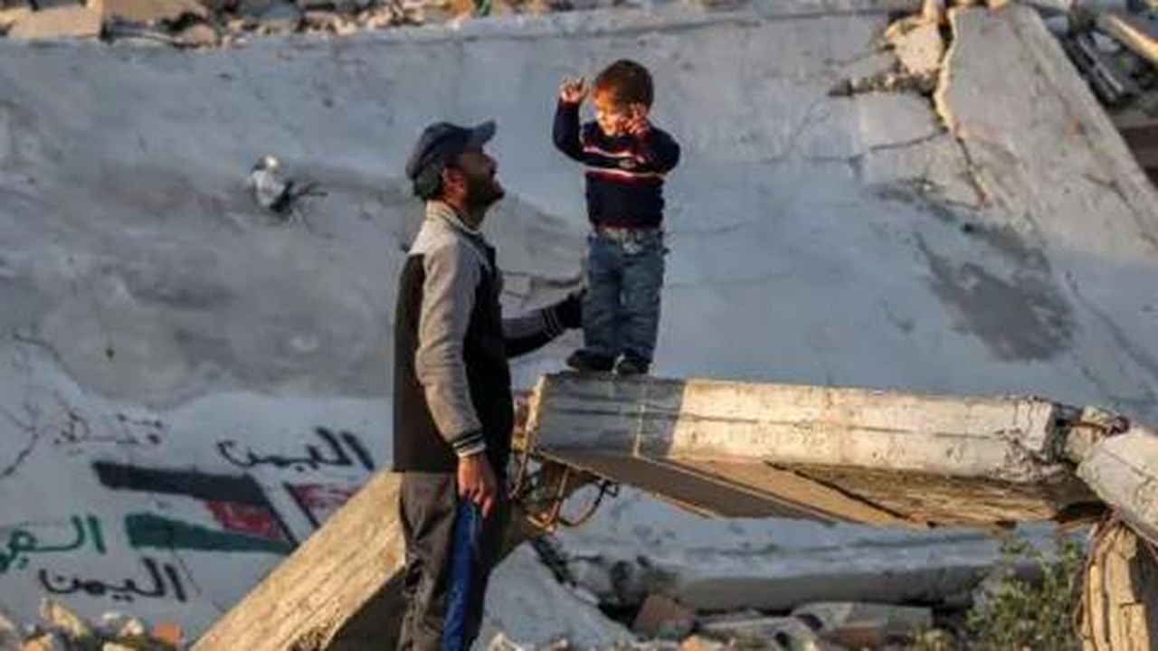 source:BBC World News - Situazione a Gaza - Un uomo parla con un ragazzo tra le macerie a Gaza.